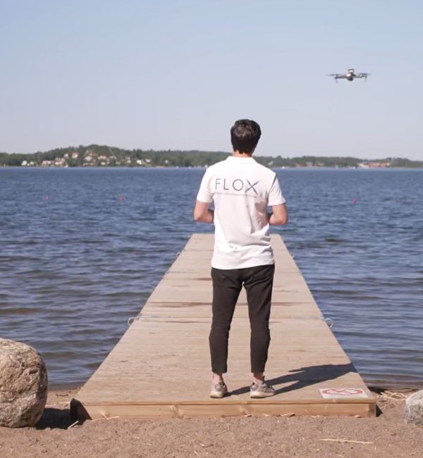 FLOX robotics team flying drone over lake.